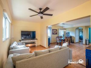 a living room with a couch and a ceiling fan at Casa Estrella, Relaxation Begins in Sosúa