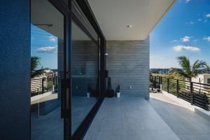 a house with a large glass door to a balcony at Luxury Villa Maeda Unit2 in Onna