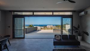 a living room with a couch and a large glass door at Luxury Villa Maeda Unit2 in Onna +67 photos