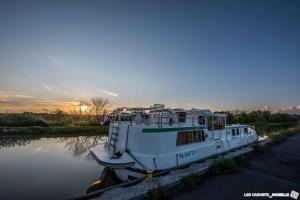 a boat is docked in the water at sunset at Au relais in Sarralbe