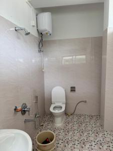 a bathroom with a toilet and a sink at KmK Homestay in Rupa
