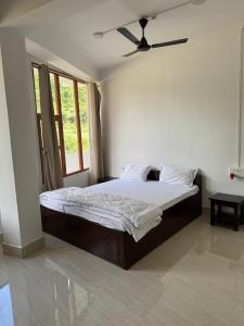 a bedroom with a bed with a ceiling fan at KmK Homestay in Rupa