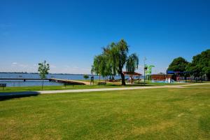a park with a bench and a pier next to the water at Bank's Place in Yarrawonga