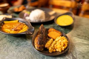 a table with plates of food on a table at Sands - Tajpur in Tajpur