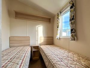 two beds in a room with a window at The Rochester - Uk51003 in Eastchurch +8 photos
