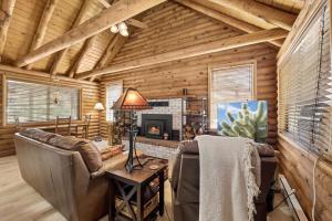 a living room with a fireplace in a log cabin at Forest Hideaway Near Sedona in Munds Park