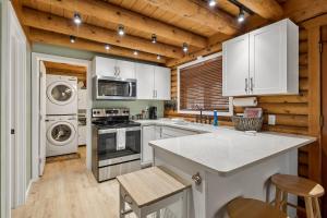 a kitchen with white appliances and wooden walls at Forest Hideaway Near Sedona in Munds Park