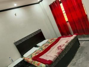 a bedroom with a bed with a red window at Al Shahzan Hotel in Lahore