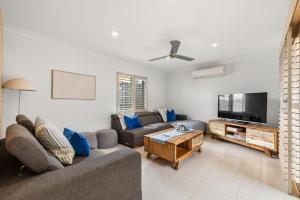 a living room with a couch and a flat screen tv at Pet Friendly Beachside Hideaway - Lazy on Lowry in Woorim