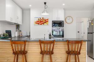 a kitchen with two chairs and a counter top at Pet Friendly Beachside Hideaway - Lazy on Lowry in Woorim