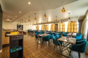 a dining room with tables and blue chairs at Mosaic Connect Ayodhya in Ayodhya