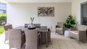 a dining room with a table and chairs at Waterline Direct Poolside Apartment in Agnes Water +14 photos
