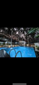 a large blue swimming pool with two chairs around it at Sanoraaa Resort in Dabolim