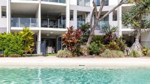 an apartment building with a pool in front of it at Waterline Direct Poolside Apartment in Agnes Water