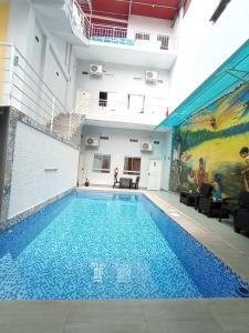 a large swimming pool in a building with a mural at Mi Quinta Raíz Loft Apartments in Iquitos
