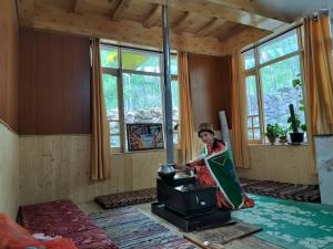 a woman standing in a room with a stove at Aama Homestay in Tabo