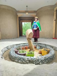 a woman is standing in front of a garden at Aama Homestay in Tabo +22 photos