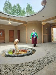 a woman standing in front of a fountain in a building at Aama Homestay in Tabo