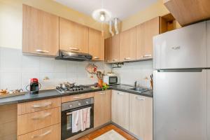 a kitchen with wooden cabinets and a refrigerator at Sunset in Baveno: 1 Bed with Balcony - Happy Rentals in Baveno