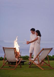 a man and woman standing next to a fire pit at Bali Beach Glamping in Tabanan +38 photos
