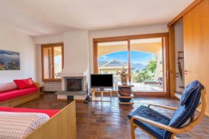 a living room with a bed and a tv and a couch at Sunset in Ranco: Lakeview Townhouse with Private Garden - Happy Rentals in Ranco