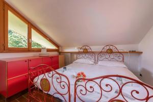 a bedroom with a red bed and a window at Sunset in Ranco: Lakeview Townhouse with Private Garden - Happy Rentals in Ranco