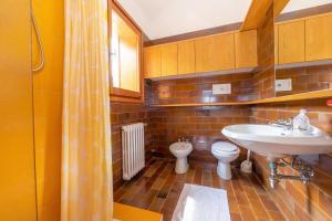 a bathroom with a sink and a toilet at Sunset in Ranco: Lakeview Townhouse with Private Garden - Happy Rentals in Ranco +24 photos