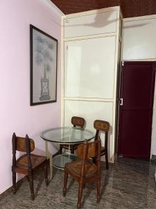 a glass table and two chairs and a glass table and chairs at VallabhanAnnexHomestay in Varkala