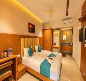 a bedroom with a large bed and a television at Hotel Morya Suites IGI Airport in New Delhi