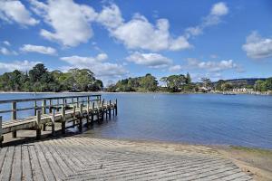 a dock on a body of water at Orford Waterfront Cottage in Orford