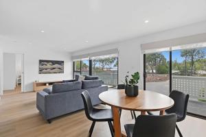 a living room with a couch and a table and chairs at Orford Waterfront Cottage in Orford