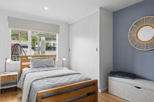 a bedroom with a bed and a mirror on the wall at Orford Waterfront Cottage in Orford +18 photos