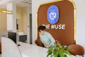 a woman sitting at a table in an office at The Muse Hotel 1 in Ðố Sơn +149 photos