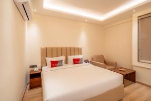a bedroom with a large white bed and a chair at Playsales SSR in Indore