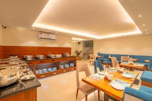 a dining room with tables and chairs and a kitchen at Playsales SSR in Indore +12 photos