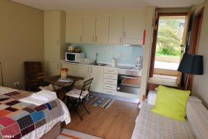 a room with a kitchen and a bed and a table at Quinta das Leiras in Santo Tirso