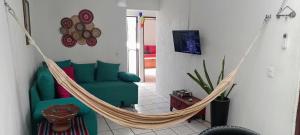 a hammock in a living room with a green couch at descanso ideal con alberca in Cihuatlan