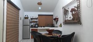 a kitchen with a table and chairs and a refrigerator at descanso ideal con alberca in Cihuatlan