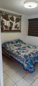 a bedroom with a bed with a blue and white comforter at descanso ideal con alberca in Cihuatlan +38 photos