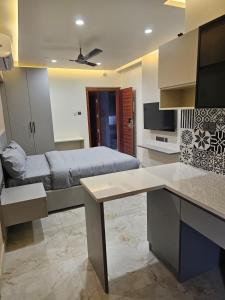 a room with a bed and a desk in it at Babus Serviced Apartments in Coimbatore