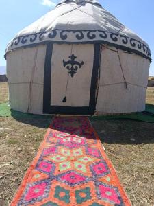 a dome tent with a rug on the ground at eco house "QUMUSH YURT" in Emgekchil