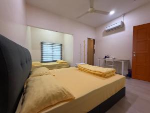 a bedroom with two beds and a window at Ipoh TZY's Homestay in Ipoh