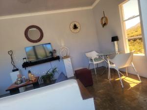 a living room with a television and a table and chairs at 1010 On The Edge in Mokhotlong