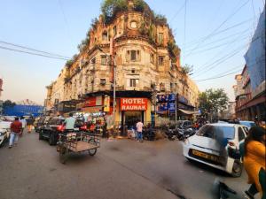 an old building on a busy city street with cars at Hotel Raunak in Kolkata