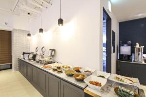 Eine Küche mit vielen Schüsseln voller Essen auf der Theke in der Unterkunft KNox Hotel in Cheonan