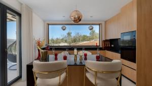 a kitchen with a dining table with chairs and a large window at Vila Laguna Blu by Villas Guide in Trget