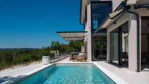 a house with a swimming pool next to a house at Vila Laguna Blu by Villas Guide in Trget