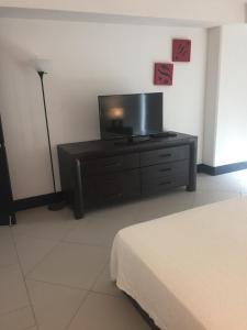 1 dormitorio con vestidor y TV de pantalla plana en Bay View Grand Marina Condo 1004S en Ixtapa