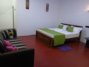 a bedroom with a bed and a couch and a chair at Canal Resort Udawalawa in Ratkarawwa +3 photos