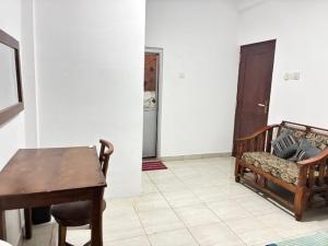 a room with a table and a bench and a table and chair at Amani Rooms in Panadura